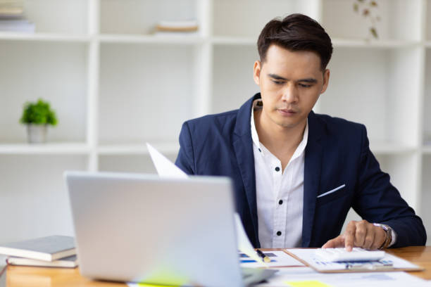 istock Businessman working on document on laptop in office. 1462669679