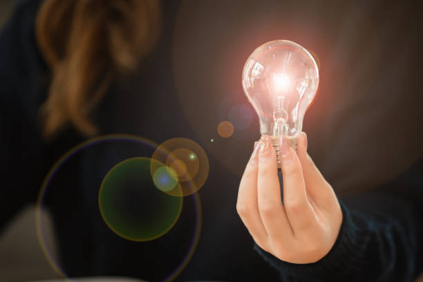 istock Woman holding a light bulb in her hand. 1462671476