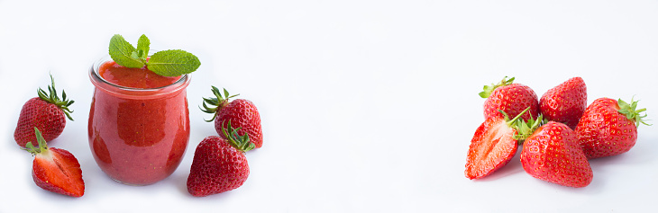 Smoothie with strawberry in the glass jar and ripe strawberry on the white background. Copy space. Banner. Close-up.
