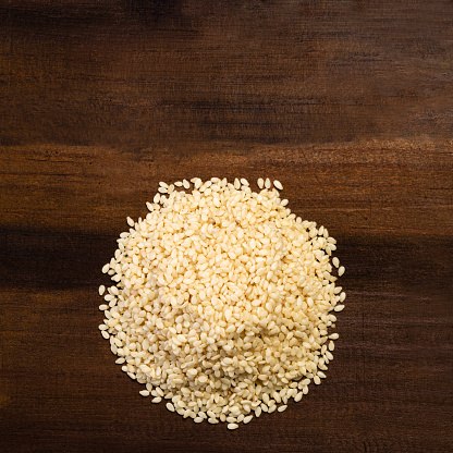 Close up view of sesame seeds on rustic wood table in the kitchen