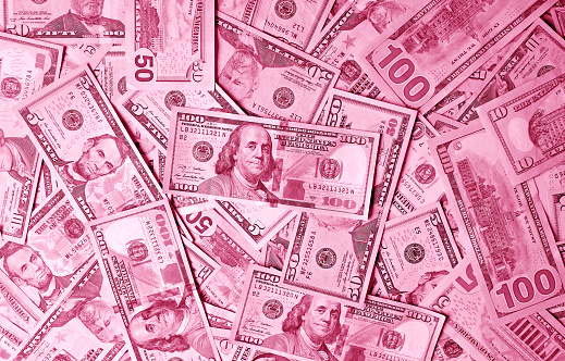Surreal pop art style heap of magenta pink colored United States dollar bills for business and wealth concept