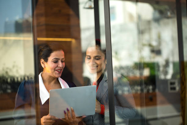 istock Two happy businesswoman discussing and using laptop at office 1462676195