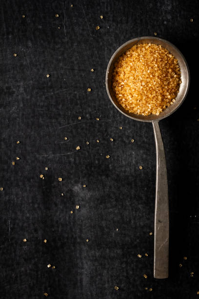 istock Big old spoon with brown sugar on black background 1462678297