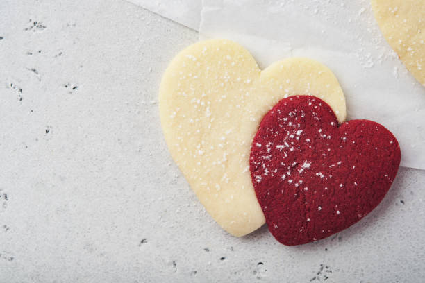 Valentines day cookies. Shortbread cookies inside sweet red heart with chocolate glaze on pink plate on grey background. Mothers day. Womans day. Sweet holidays baking. Valentines day card. Top view. galletas de san valentín. galletas de mantequilla dentro de corazón rojo dulce con glaseado de chocolate sobre plato rosa sobre fondo gris. día de la madre. día de la mujer. dulces vacaciones horneando. tarjeta de san valentín. vista superior.