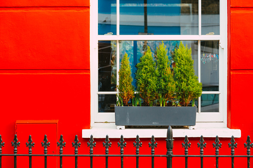The colorful red facade of a traditional terraced London mews townhouse.