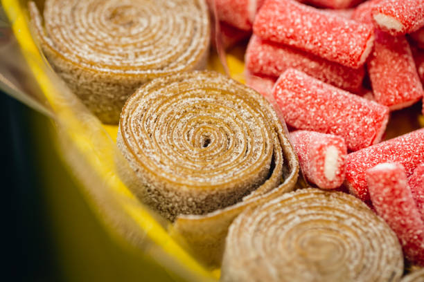 Close-up, background with rolled gummies coated with sugar, macro shot.