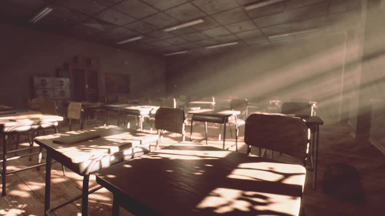 View to classroom with tables and small blackboard and grungy walls