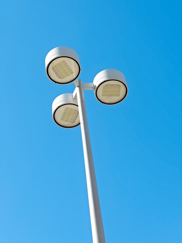 Classical style street lamps in front of a blue sky