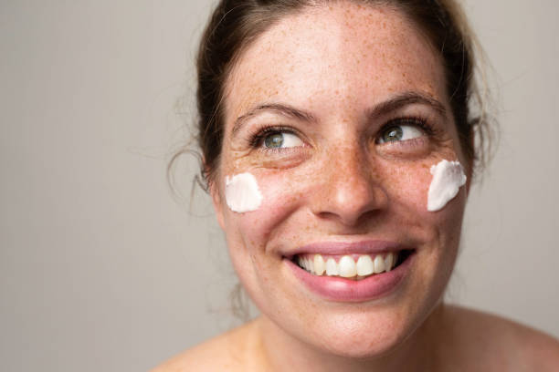 istock Freckled smiling girl with cream on her face 1462686601
