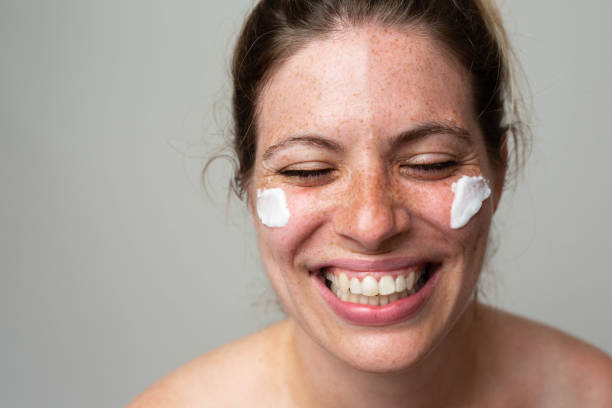 istock Freckled smiling girl with cream on her face 1462686641