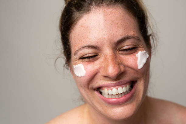 istock Freckled smiling girl with cream on her face 1462686669
