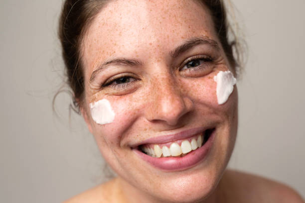 istock Freckled smiling girl with cream on her face 1462686687