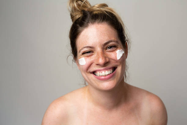 istock Freckled smiling girl with cream on her face 1462686732