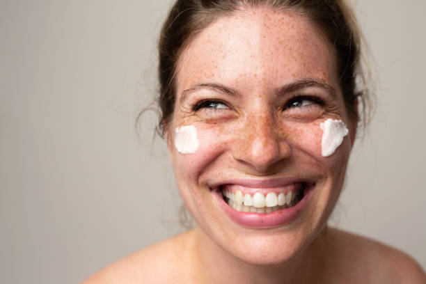 istock Freckled smiling girl with cream on her face 1462686735