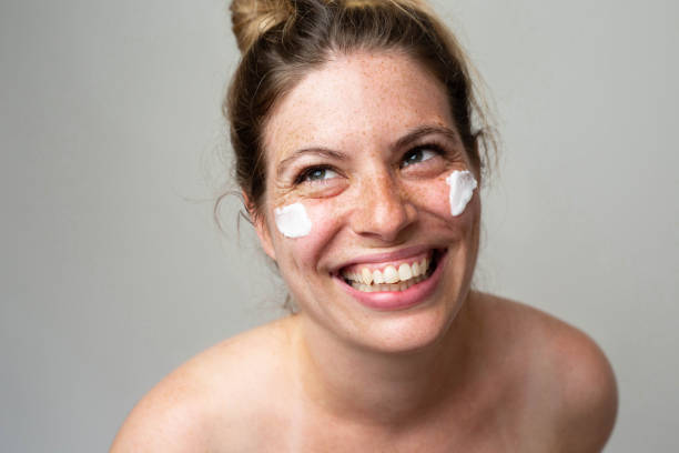 istock Freckled smiling girl with cream on her face 1462686781