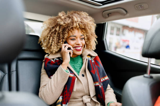 istock A woman talking on her mobile phone while smiling in the car 1462688881