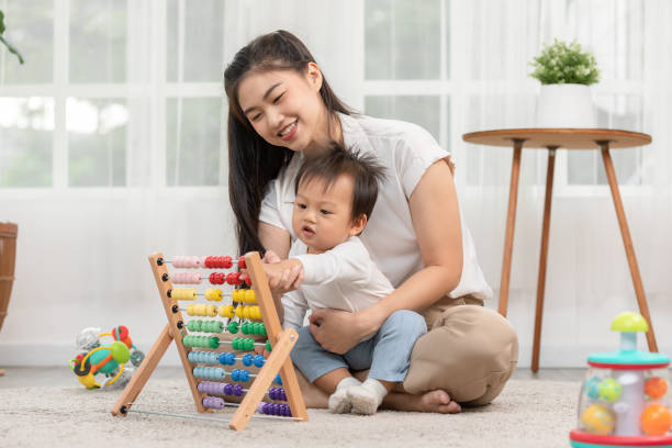 istock Asian mom teaching baby boy learning and playing toys for development skill at home or nursery room. Happiness mother and baby spending time together at warmth place. Good moment with mom and baby 1462691887