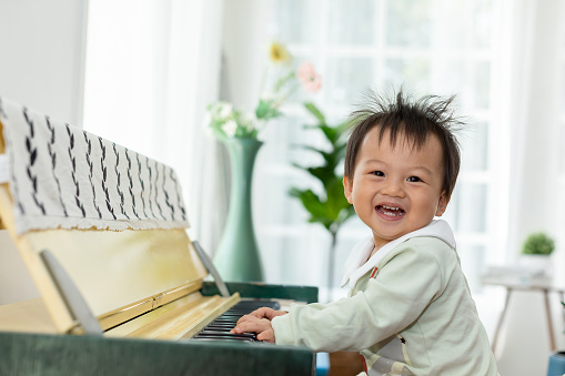 Caucasian Little boy learning how to play piano