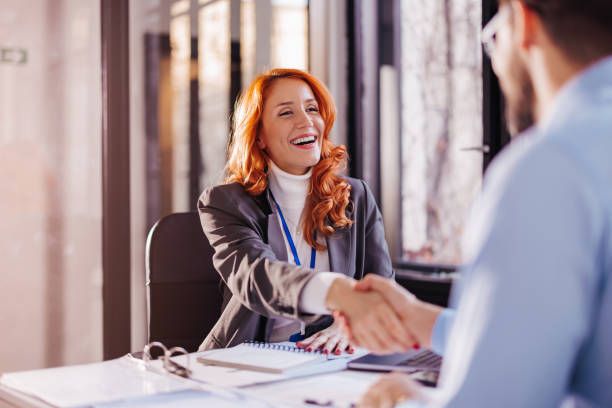 istock a young woman smiling and shaking hands with a client, after concluding a contract 1462694793