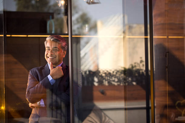 istock Cheerful businessman looking away through glass window 1462698043