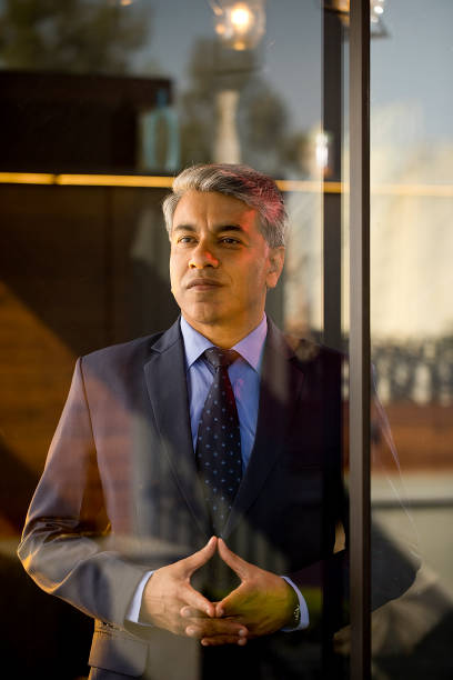 Thoughtful businessman looking through glass window
