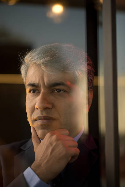 istock Thoughtful businessman looking through glass window 1462699753