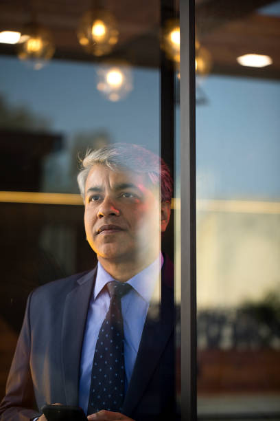 istock Thoughtful businessman looking through glass window 1462699811
