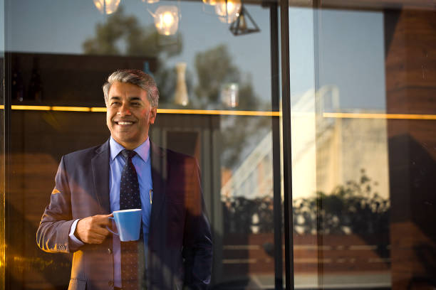 istock Happy businessman drinking coffee at office 1462700228