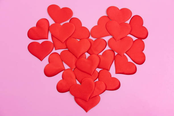 istock Red heart shape consisting of many small hearts on a pink background. A creative Declaration of love. 1462705344