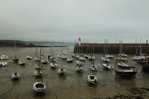 Boats Lying Aground During Low Tide  In The Harbour Of Erquy In Bretagne France On An Overcast Summer Day