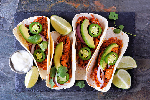 Jackfruit vegan tacos. Top view over a dark background. Healthy eating, plant-based pulled pork meat substitute.