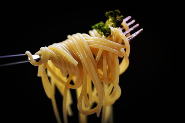 istock Spaghetti on fork and black background - spaghetti italian pasta with parsley in the restaurant italian food and menu concept 1462713200