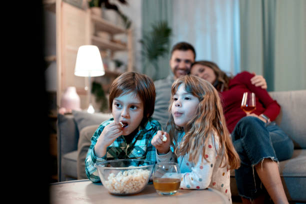 istock Brother and sister eating popcorn 1462716024