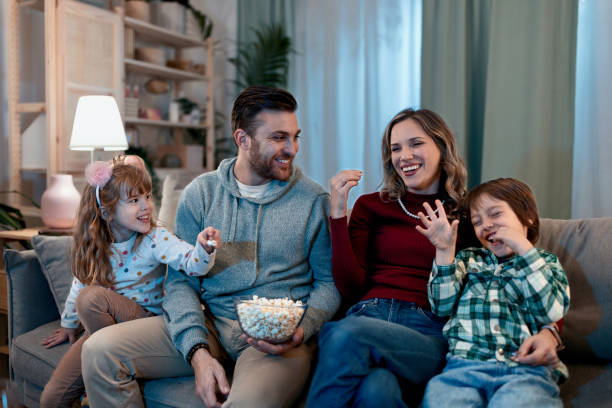 istock Happy family eating popcorn while watching something on the TV 1462716120