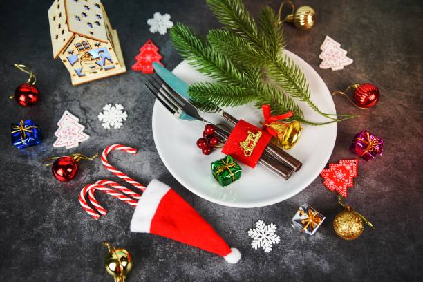 istock Christmas table place setting decoration with gift box ball candy cane in santa claus hat fork and knife plate Xmas New Year food lunch festive Christmas dinner holidays background themed party 1462719179
