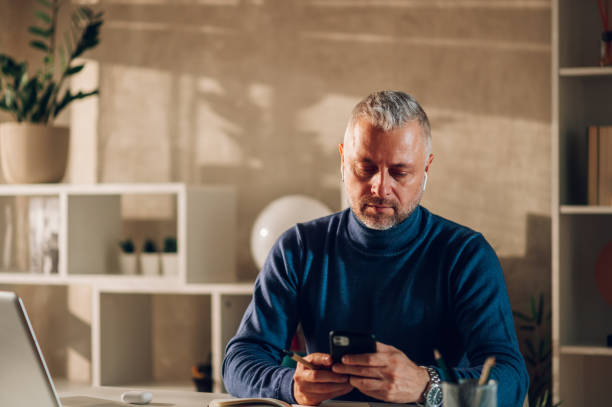 istock Middle aged man working in a home office and using smartphone 1462720833