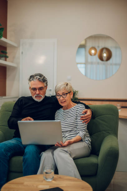 istock Senior couple using laptop while sitting on a couch at home 1462720858