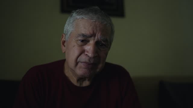 Portrait of a senior man crying in living room at home