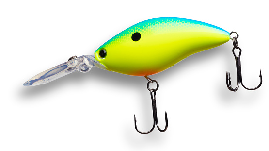 Yellow and blue fishing lure with shadow seen from the side