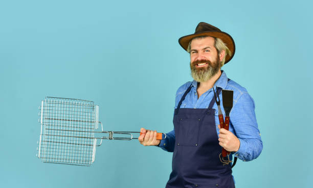 istock Culinary concept. Bachelor day. Medium rare. Tools roasting meat. Man in apron hold barbecue grill. Cooking steak. Cooking utensils. Farmer with bbq equipment. Summer picnic. Bbq american tradition 1462743460