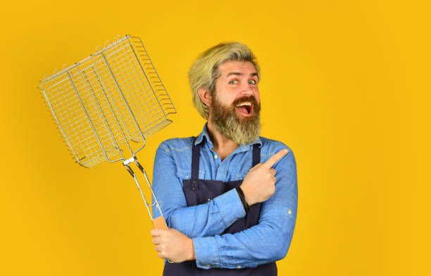 istock Grilled and smoked. bearded man chef. Tools for roasting meat outdoors. Picnic and barbecue. ready for barbecue party. Culinary concept. summer weekend. hipster hold cooking utensils for barbecue 1462743987