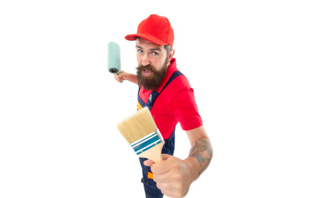 istock surprised bearded decorator with paintroller in studio. decorator with paintroller isolated on white 1462744646