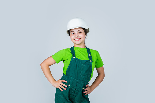 Assistant. Portrait of little girl with hard hat. Little girl in hard hat play in workshop. Child protection and safety. Little smiling builder in helmet. happy childhood. career guidance idea.