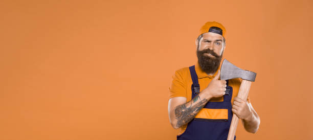 istock making his beard shape. Agriculture and forestry theme. Power and strength. Danger concept. Brutal lumberjack with iron axe. concept of hairdressing. copy space. Handsome happy man with axe 1462746890