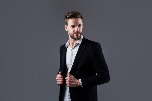 Portrait of a young handsome caucasian man standing with arms crossed in the city.