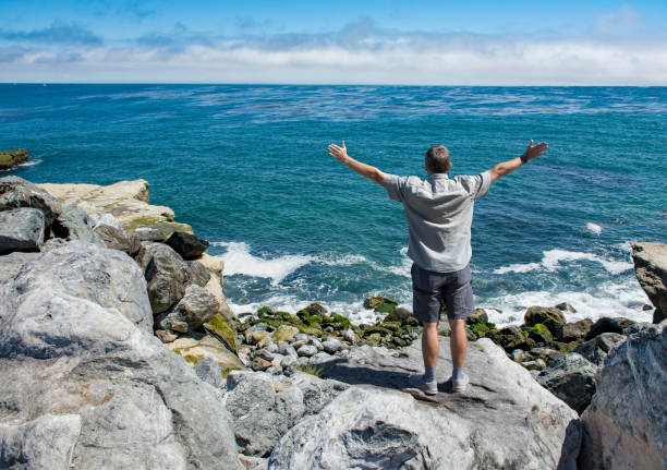 istock Man enjoying day on the ocean shore in California. 1462750197