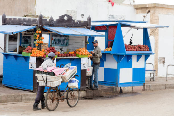 Marrakesh, Morocco - January 27, 2020: Street scene, a cyclist carrying goods through the downtown Marrakesh, Morocco.