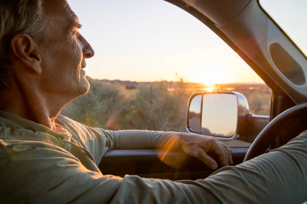 istock Mature man drives vehicle along rural road 1462764679