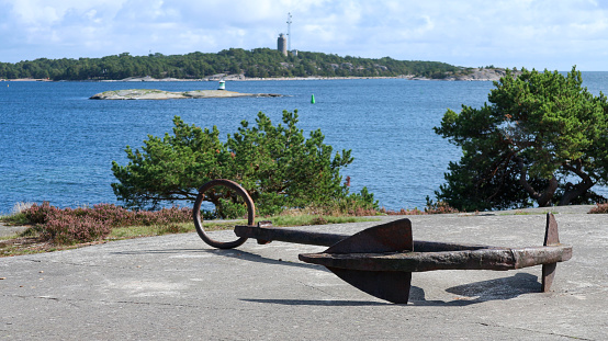 view of an anchor lying on land with the archipelago in the background