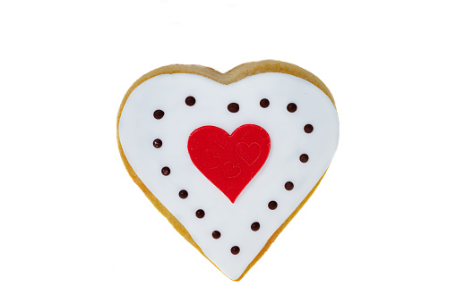 Heart shaped cookies with raspberry jam, sprinkled with powdered sugar on light gray background. Valentine's Day or Christmas biscuits making process.